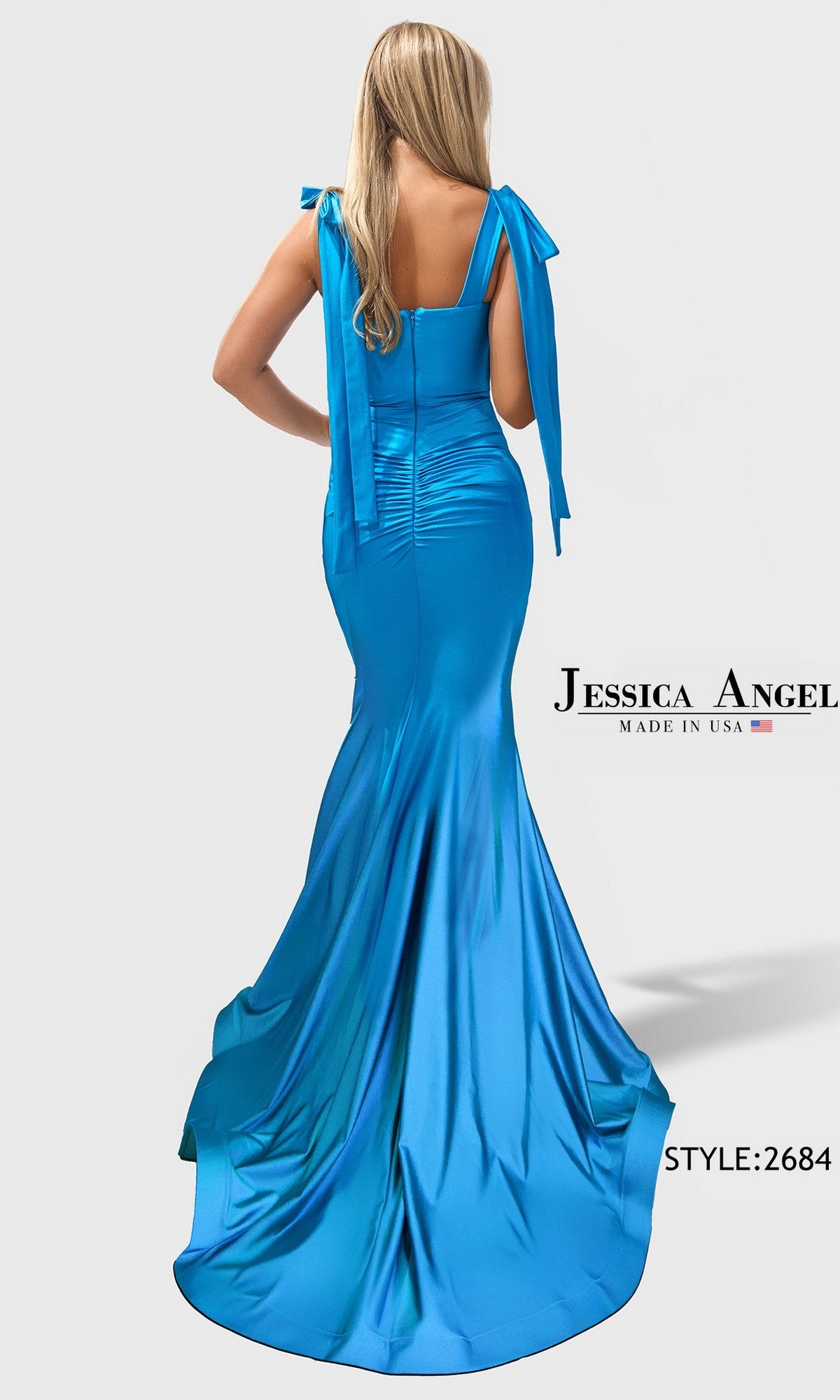 A woman wearing the Long Prom Dress: Jessica Angel 2684—a bright blue, floor-length fitted gown with ribbon-tie shoulder straps, shiny satin fabric, a slight train—shown from the back.